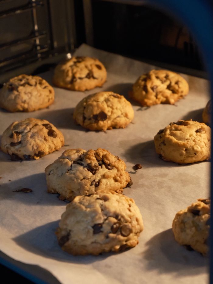 Warm chocolate chip cookies baking in an oven, perfect for dessert lovers.